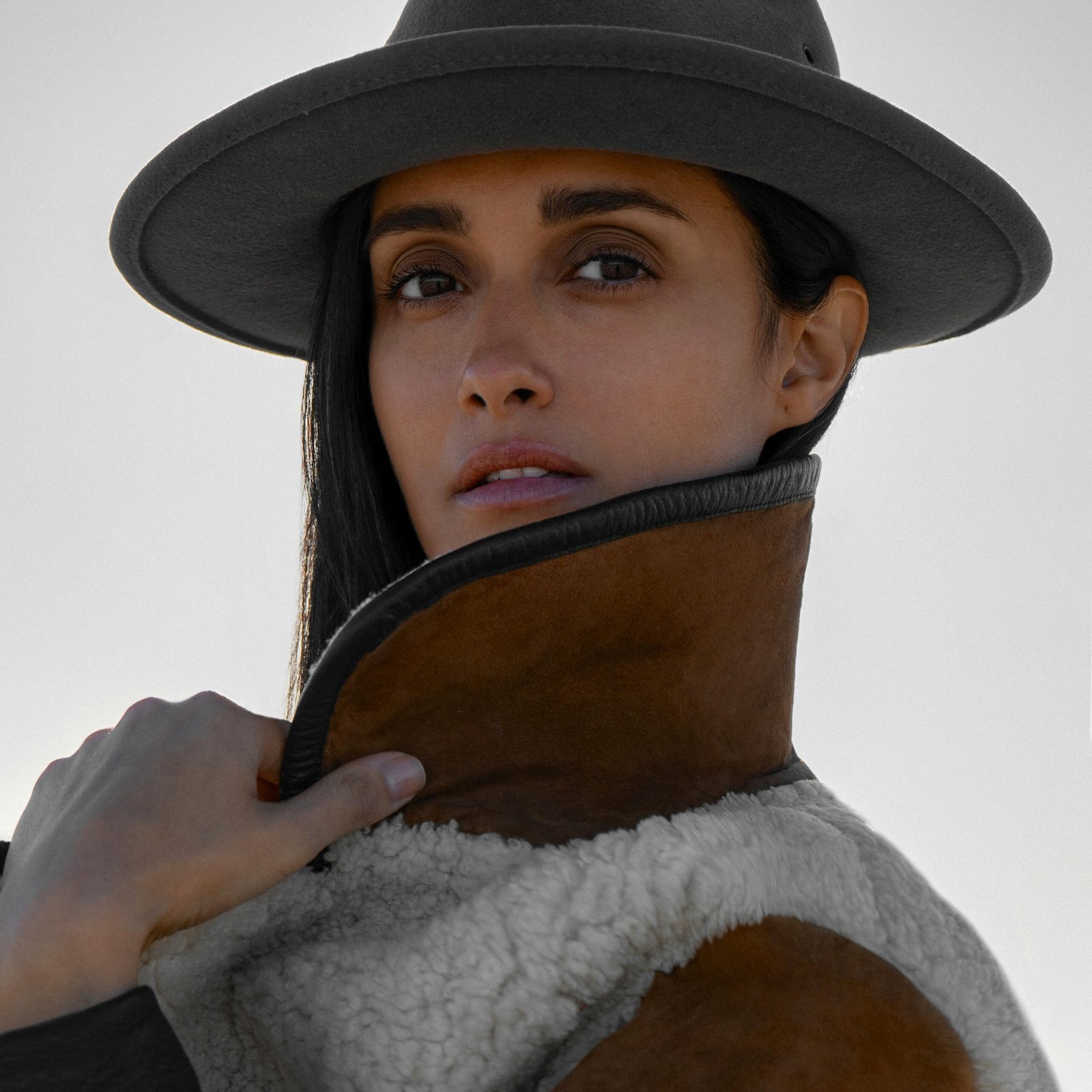 Portrait of a woman in a stylish hat and warm jacket with a confident look.